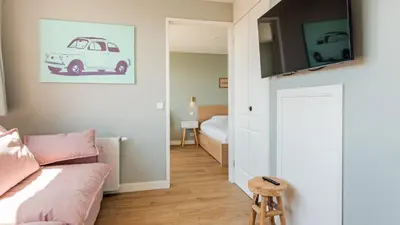 a living room with a couch and a bed at Goudkust 3 'At Sea' in Bergen