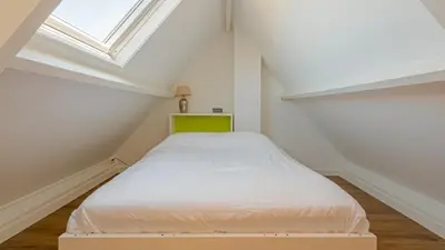 a small bedroom with a bed in the attic at Goudkust 3 'At Sea' in Bergen