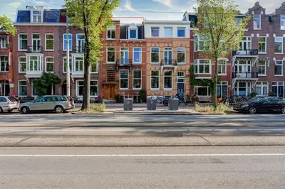 an empty street with cars parked in front of buildings at B&B Numero 14 in Amsterdam