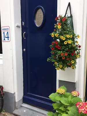 a blue door with a wreath of flowers on it at B&B Numero 14 in Amsterdam