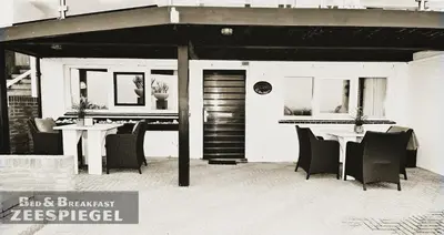 a restaurant with chairs and a table in front of it at B&B Zeespiegel in Zandvoort