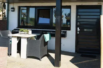 a table and chairs in front of a building with a door at B&B Zeespiegel in Zandvoort