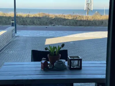 a wooden table with a clock and a plant on it at B&B Zeespiegel in Zandvoort