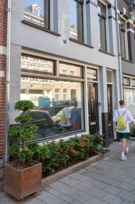 a woman walking past a window of a store at Het Kabinet in Amsterdam