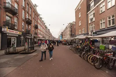 a couple of people walking down a city street at Het Kabinet in Amsterdam