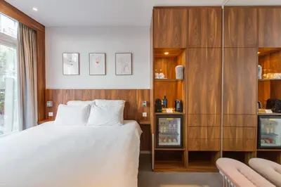 a bedroom with a white bed and wooden cabinets at Het Kabinet in Amsterdam