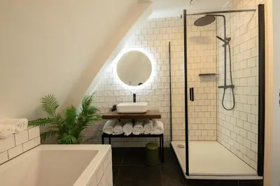 a bathroom with a tub and a sink and a shower at Poort Beach Boutique Apartments in Bloemendaal Aan Zee