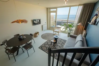 a living room with a couch and a table at Poort Beach Boutique Apartments in Bloemendaal Aan Zee