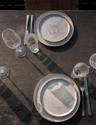 a table with plates and utensils on a table at Poort Beach Boutique Apartments in Bloemendaal Aan Zee