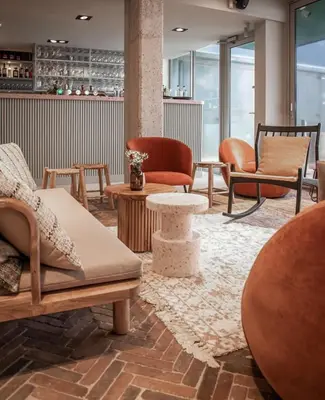 a lobby with chairs and tables in a room at Poort Beach Boutique Apartments in Bloemendaal Aan Zee