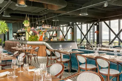 a restaurant with tables and chairs and a bar at Corendon Urban Amsterdam Schiphol Airport Hotel in Badhoevedorp