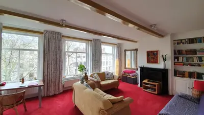 a living room with a couch and a tv at Large Historical Apartment & Canal Terrace in Utrecht