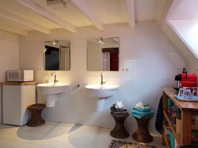 a bathroom with two sinks and two mirrors at Large Historical Apartment & Canal Terrace in Utrecht