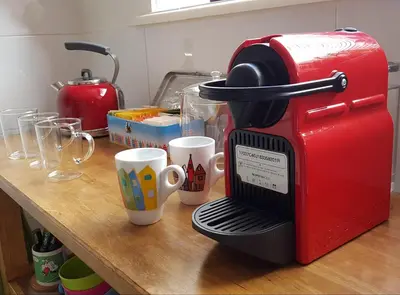 a red coffee maker sitting on a table with cups at Large Historical Apartment & Canal Terrace in Utrecht