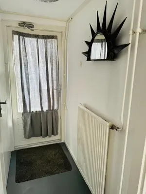 a small room with a window and a radiator at Zomerhuis Rita in Egmond aan Zee