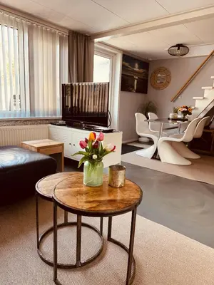 a living room with a vase of flowers on a table at Zomerhuis Rita in Egmond aan Zee