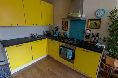 a kitchen with yellow cabinets and a sink at SOEPP hotel & restaurant in Alkmaar