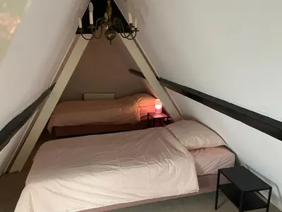 two twin beds in a attic room with a lamp at SOEPP hotel & restaurant in Alkmaar