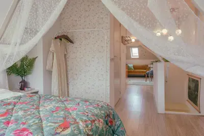 a bedroom with a canopy bed and a living room at SOEPP hotel & restaurant in Alkmaar