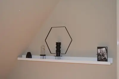 a shelf with a mirror on a wall at Minime in Bergen