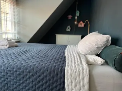 a bedroom with a bed with white sheets and pillows at Minime in Bergen