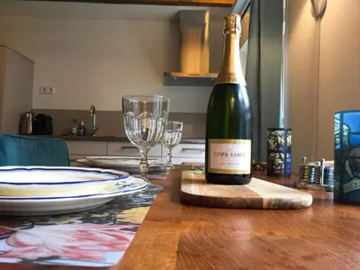 a bottle of wine sitting on a wooden table at Apple Tree Cottage - charming home at beautiful canal in our idyllic garden in Gouda