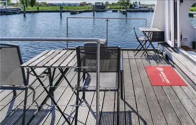 two chairs and a table on the deck of a boat at Aquacabin in Aalsmeer