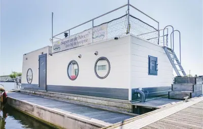 a white building on the water next to a dock at Aquacabin in Aalsmeer