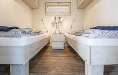 two beds in a room with wooden floors at Aqualiving in Aalsmeer