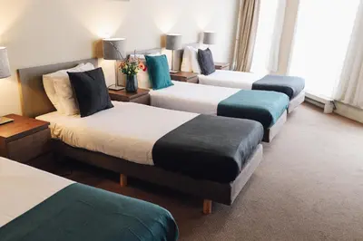 a hotel room with four beds with blue and white at Hotel Corner House in Amsterdam