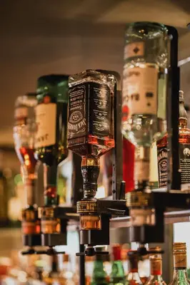 a row of bottles of alcohol on a bar at Hotel Corner House in Amsterdam
