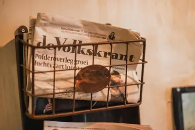 a basket with a newspaper and a boy in a bed at Hotel Corner House in Amsterdam