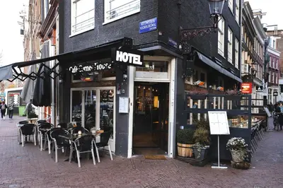 a restaurant with tables and chairs outside of a building at Hotel Corner House in Amsterdam