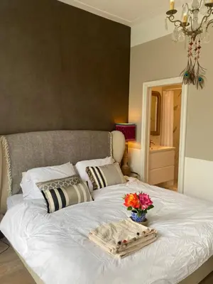a white bed with a tray of flowers on it at Vondelpark Suite in Amsterdam