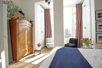 a bedroom with a bed and a large window at Vondelpark Suite in Amsterdam