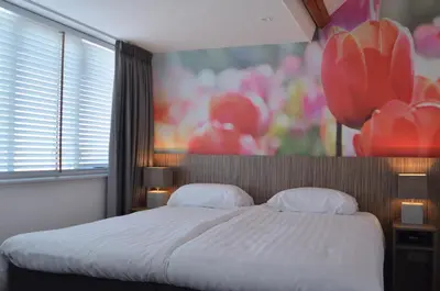 a bedroom with a large bed and a large window at Hotel Restaurant de Engel in Lisse