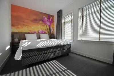 a bedroom with a bed and a painting on the wall at Hotel Restaurant de Engel in Lisse