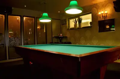 a billiard table in a room with green lighting at Hotel Restaurant de Engel in Lisse