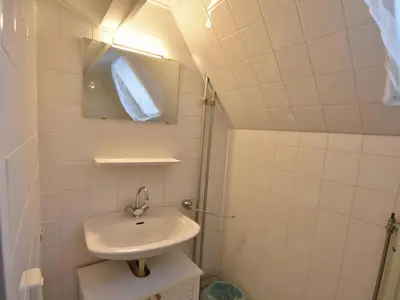 a small bathroom with a sink and a mirror at Holiday Home Bergen aan Zee near Beach in Bergen aan Zee