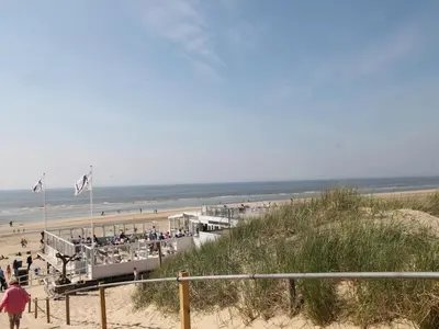a beach with people on the sand and the ocean at Holiday Home Bergen aan Zee near Beach in Bergen aan Zee
