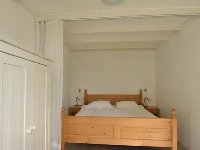 a bedroom with a wooden bed with two pillows at Holiday Home Bergen aan Zee near Beach in Bergen aan Zee