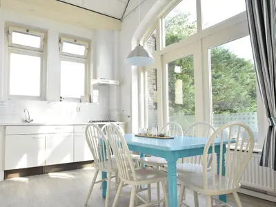 a kitchen with a blue table and chairs at Holiday Home Bergen aan Zee near Beach in Bergen aan Zee