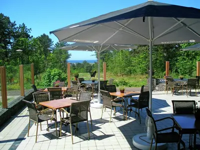 a patio with tables and chairs and an umbrella at Holiday Home Bergen aan Zee near Beach in Bergen aan Zee