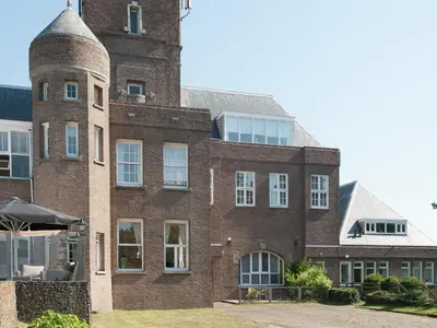 a large brick building with a tower at Apartment Bergen aan Zee near Beach in Bergen aan Zee