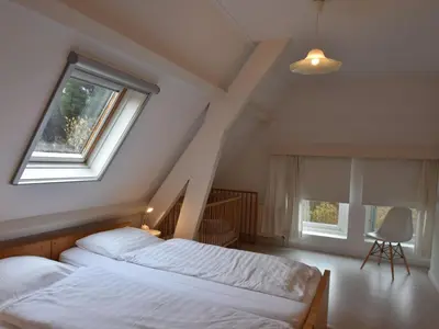 a attic bedroom with two beds and a window at Apartment Bergen aan Zee near Beach in Bergen aan Zee