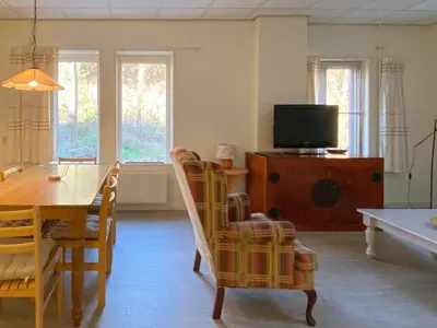 a living room with a dining table and a television at Apartment Bergen aan Zee near Beach in Bergen aan Zee