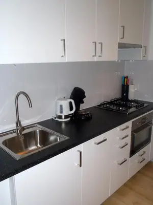 a kitchen with a sink and a toaster on a counter at Appartement Brouwer in Egmond aan Zee