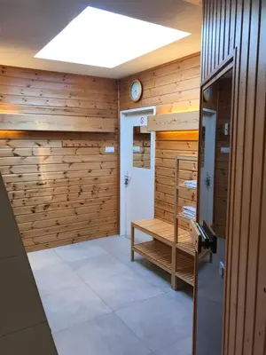 a sauna with wooden walls and a bench in a room at Appartement Brouwer in Egmond aan Zee