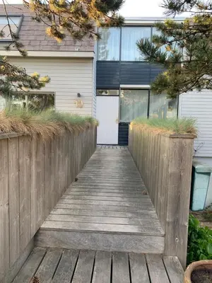 a wooden walkway leading to a house at Appartement Brouwer in Egmond aan Zee