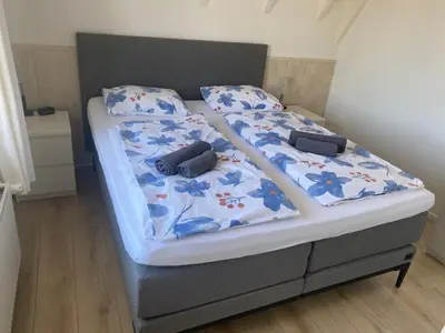 a bed with two pillows on top of it at Appartement Brouwer in Egmond aan Zee